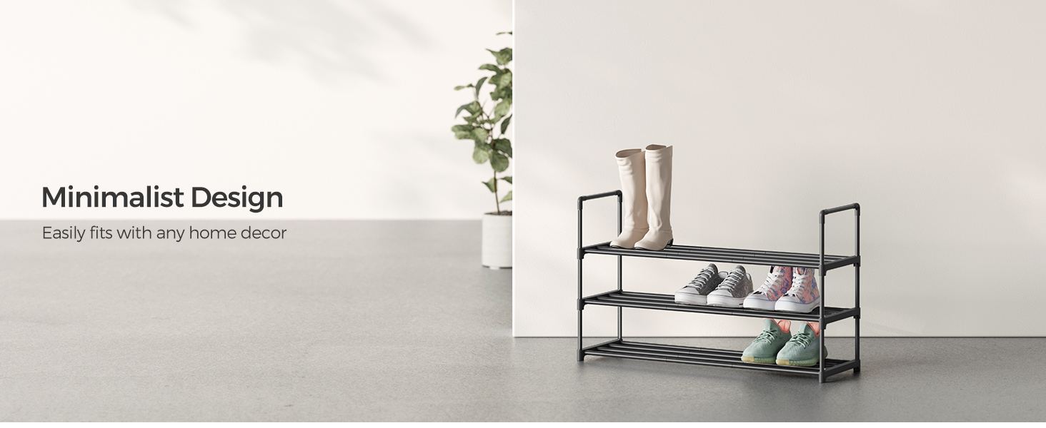Three-tier metal shoe rack with black frame and mesh shelves, displaying various shoes and boots in a minimalist setting against a light gray wall.